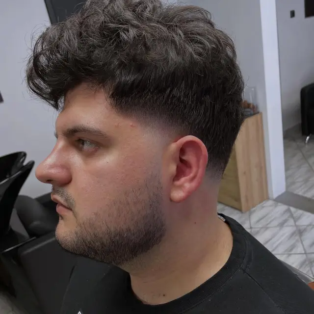 Duža kovrdžava kosa na vrhu sa low fade prelazom